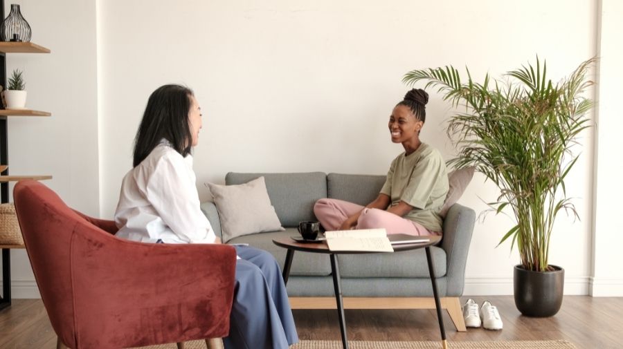 patient sitting on gray fabric couch in front of a therapist