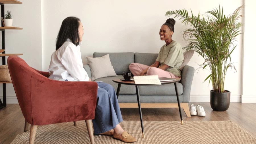 a female patient sitting on couch in front of therapist