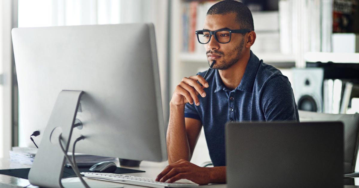 man sitting in front of computer, thoughtful