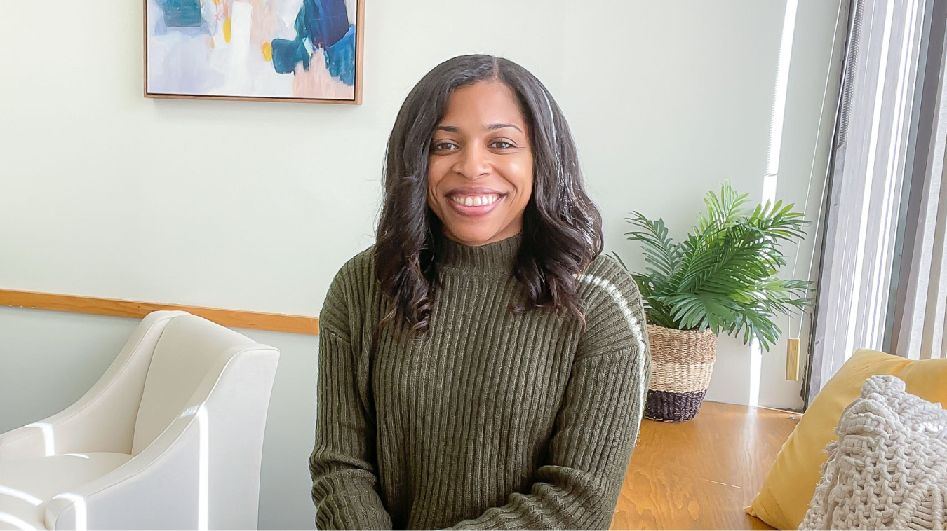 woman in a relaxed office setting smiling directly at the camera